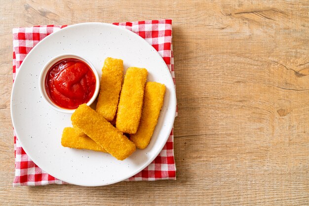 knusprig gebratene Fischstäbchen mit Semmelbröseln auf Teller serviert