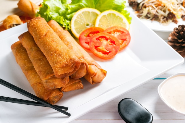 Knusprig gebratene Frühlingsrollen mit Pflaumensauce und Salat, Zitronenscheiben