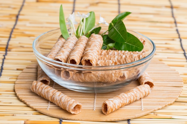 Knusprig gerollte Waffelstangen, traditionelles Dessert in Thailand, sind in der transparenten Schüssel zusammengefasst