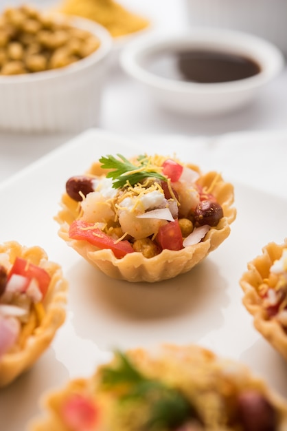 Knusprige Canape oder Canapé ist ein Starterrezept aus Indien - Rundes oder quadratisches Puri Gefüllt mit Joghurt und Kartoffeln, Chat, Sev, Tamarindensauce usw. Selektiver Fokus