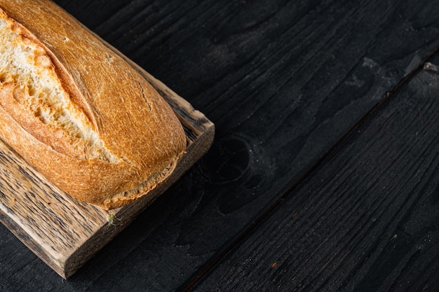 Knusprige französische Baguettes auf schwarzem Holztisch mit Kopierraum für Text