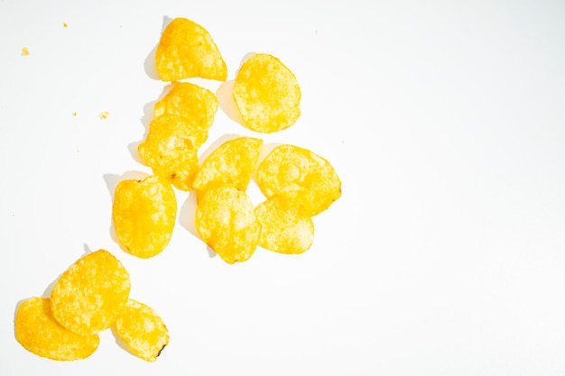 Knusprige goldene Kartoffelchips sind auf weißem Hintergrund verstreut Draufsicht flach gelegt