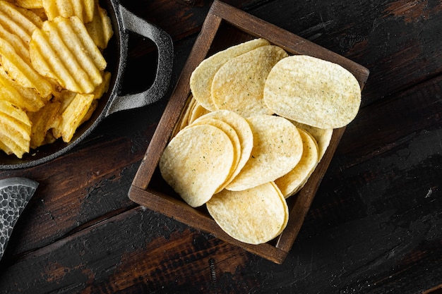 Knusprige Kartoffelchips auf altem dunklem Holztisch