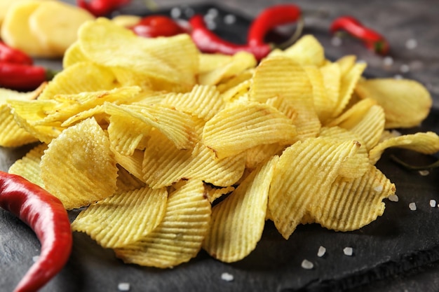 Knusprige Kartoffelchips mit Chilipfeffer auf Schieferplattennahaufnahme