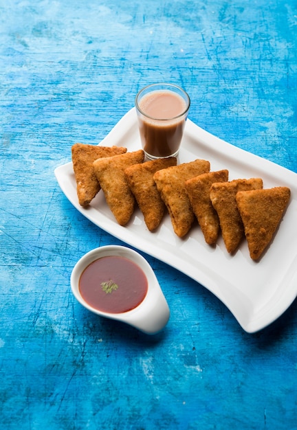 Knusprige Kartoffeldreiecke oder Batata Vada mit Semmelbrösel bedeckt und dann frittiert. serviert mit Tomatenketchup. selektiver Fokus