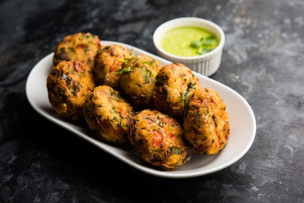 Foto knusprige mais-tikki, pakora oder pakoda oder pattice, auch als schnitzel bekannt. serviert mit grünem chutney. selektiver fokus