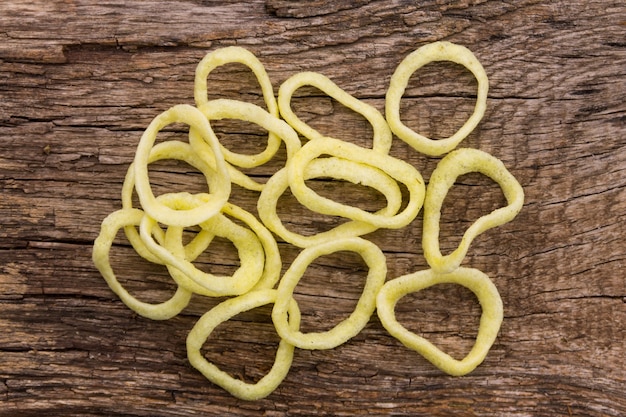 Knusprige Snacks Zwiebelringe auf Holztisch. Ansicht von oben