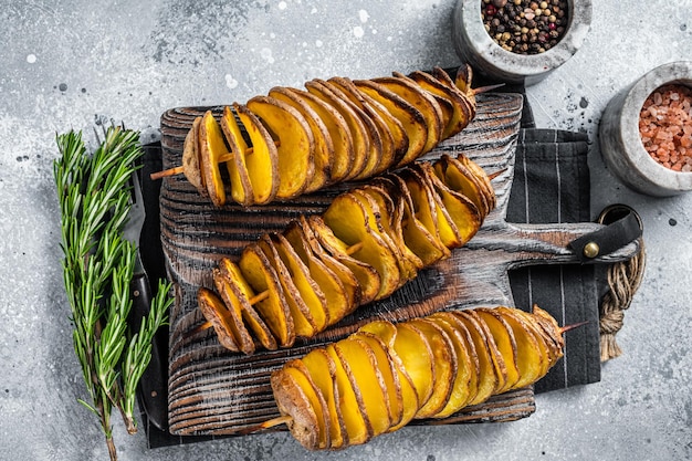 Knusprige Tornado- oder Twist-Kartoffelchips auf Holzbrett. Grauer Hintergrund. Ansicht von oben.