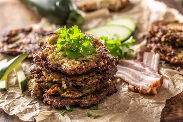 Knusprige Zucchini-Pfannkuchen mit Speck-Petersilien-Kräutern und anderen Zutaten.