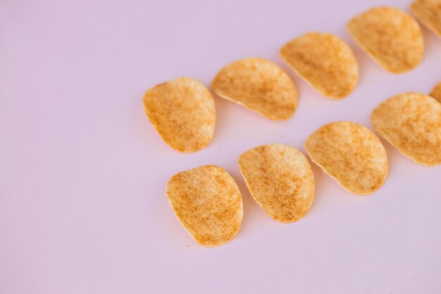 Knuspriger Kartoffelchips-Snack auf rosa Hintergrund Fast Food