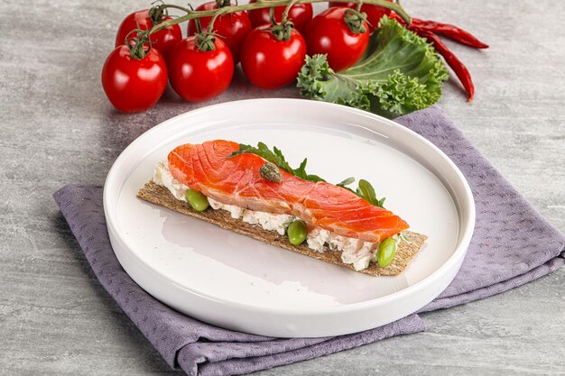 Knuspriges Brot mit Lachs und Creme-Käse serviert Rucola