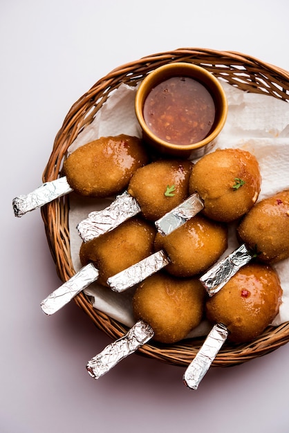 Foto knuspriges gemüse-lutscher-rezept aus gekochten kartoffeln mit gewürzen, überzogen mit maismehl und semmelbrösel und dann frittiert, serviert mit zahnstocher oder eiscreme-stick