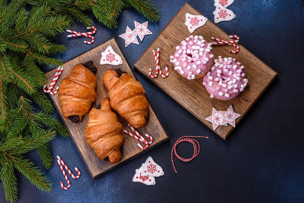 Knuspriges Schokoladencroissant mit Weihnachtsschmuck auf Holzschneidebrett