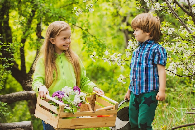 Öko lebende glückliche Kinderbauern, die Spaß auf dem Frühlingsfeld haben Kinderbauern auf dem Bauernhof mit Countr