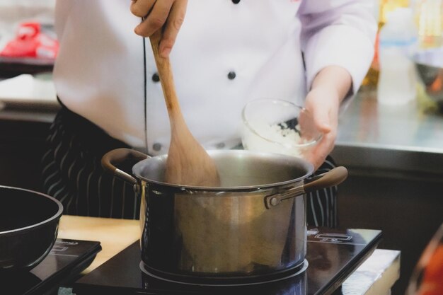 Koch bereitet das Essen in der Küche vor, kocht, schmückt das Gericht