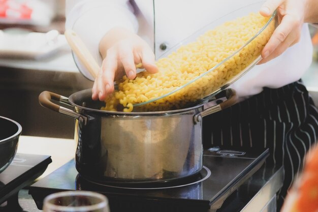 Koch bereitet das Essen in der Küche vor, kocht, schmückt das Gericht