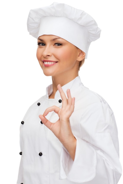 Koch-, Gesten- und Essenskonzept - lächelnde Köchin, die ein ok Handzeichen zeigt