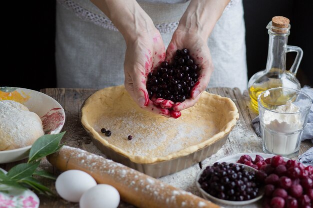 Koch gießt die Beeren in den Teig