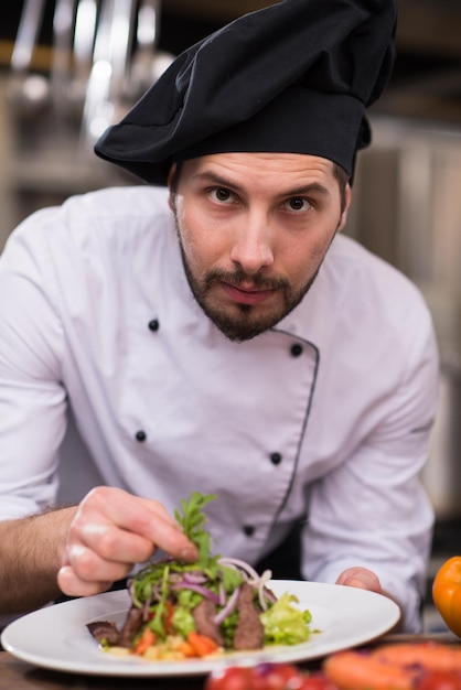 Koch Koch Dekoration Garnierung zubereitete Mahlzeit Gericht auf dem Teller in der gewerblichen Küche des Restaurants