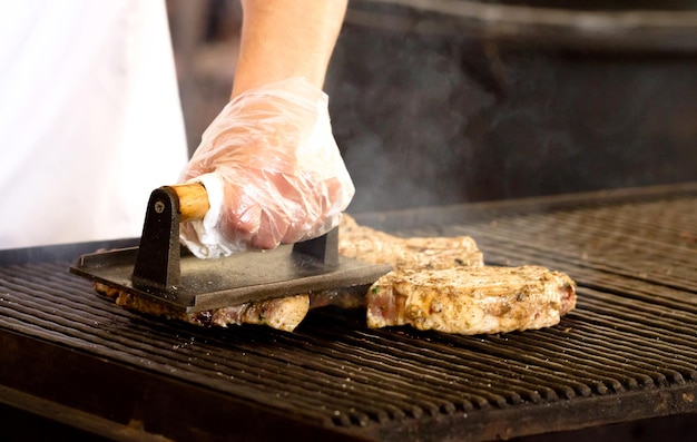 Koch kocht Steaks auf dem Grill