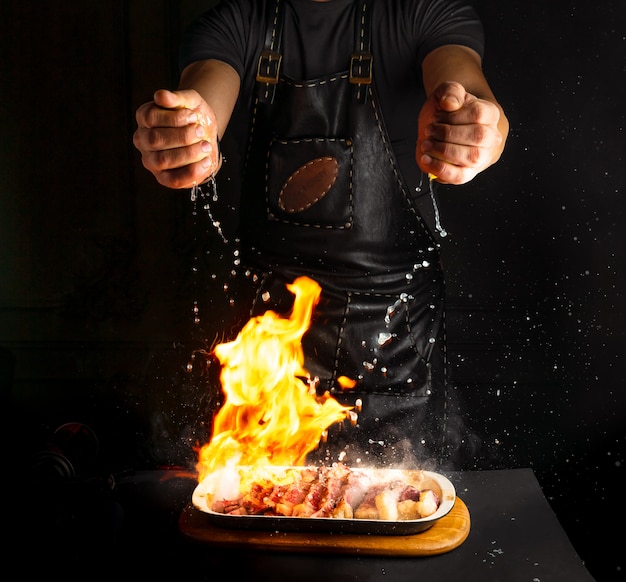 Koch streut Zitronensaft auf Flammfleisch