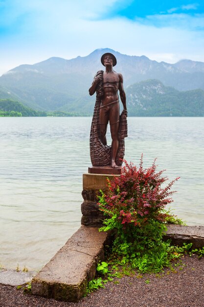 Foto kochel am see alemania 01 de julio de 2021 escultura de pescador en el lago kochelsee en la ciudad de kochel am see alemania