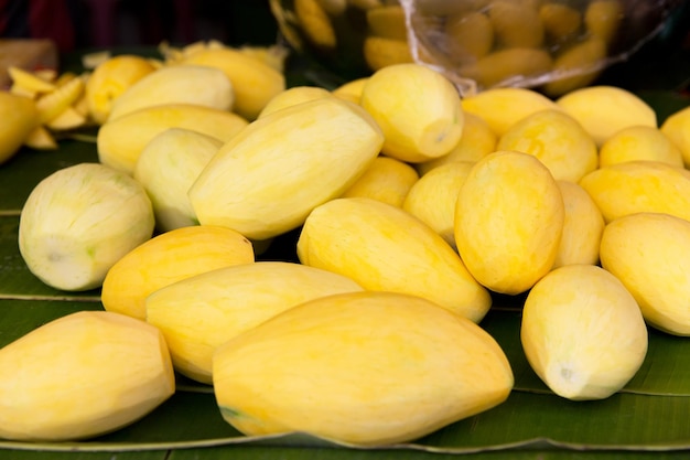 kochen, asiatische küche, verkauf und lebensmittelkonzept - geschälte mango auf dem straßenmarkt