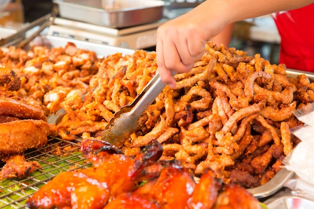 Kochen, asiatische Küche, Verkauf und Lebensmittelkonzept - Nahaufnahme von Kochhänden und Snacks auf dem Straßenmarkt