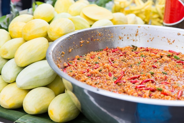 kochen, asiatische küche, verkaufs- und lebensmittelkonzept - kühler wok oder pilaf und mango auf dem straßenmarkt