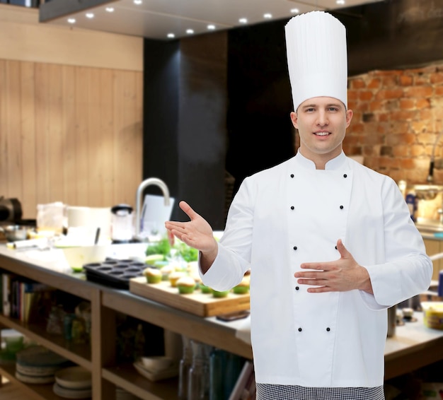 kochen, beruf und personenkonzept - glücklicher männlicher koch lädt ein