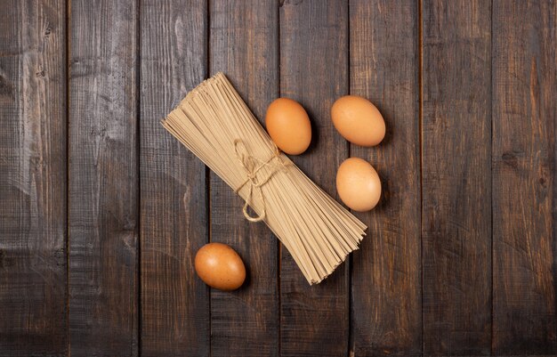 Kochen. Eier und Nudeln auf einem Holztisch.