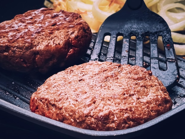 Kochen Hackfleisch Burger auf gusseisernen Grillpfanne im Freien rotes Fleisch auf der Pfanne Grillen von Speisen im Garten Englisches Landleben