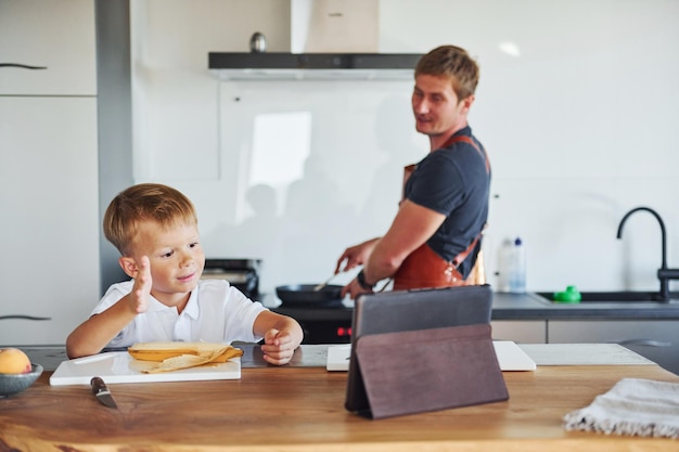 Kochen lernen mit Tablet Vater und Sohn sind gemeinsam zu Hause