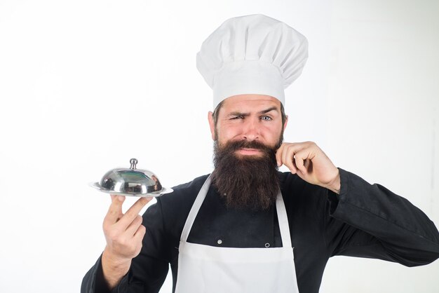 Kochen, Servieren und Präsentation bärtiger Koch präsentiert silbernes Tablett Kochkoch hält metallisches Gericht