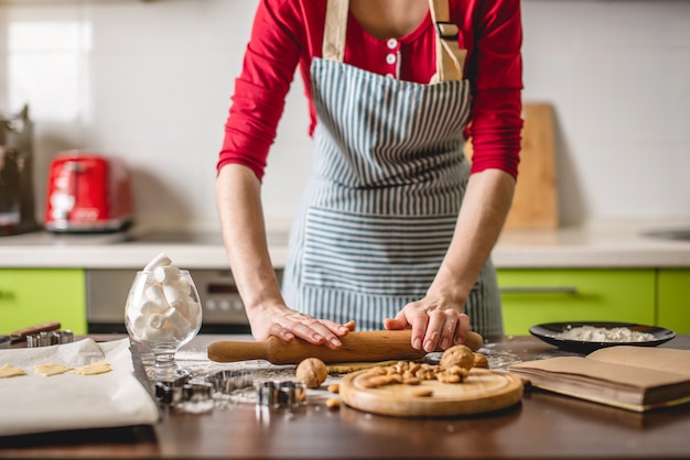 Kochen Sie Hausfrau, die Kekse zu Hause auf einer bunten Küche macht