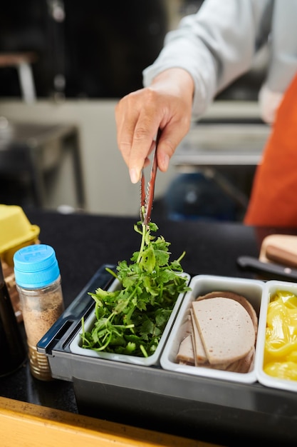 Kochen Sie, indem Sie Koriander zum Sandwich hinzufügen