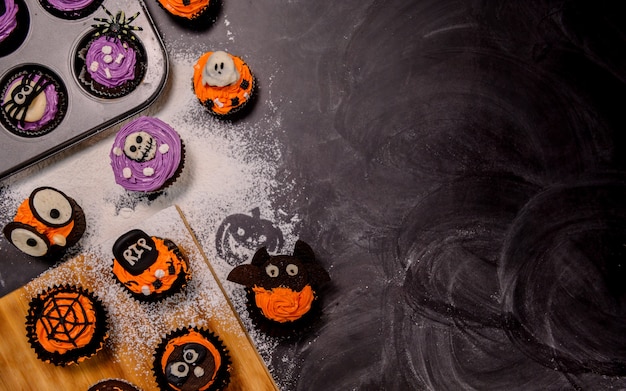 Kochen Sie köstlichen hausgemachten Kuchen und dekorieren Sie Cupcakes für Halloween festlich. Zubereiten und Mischen von Zutaten für Süßspeisendesserts in der Küche zu Hause.