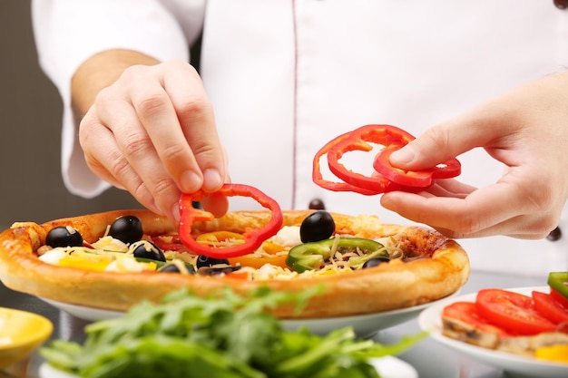 Kochen Sie leckere Pizza im Restaurant in der Nähe