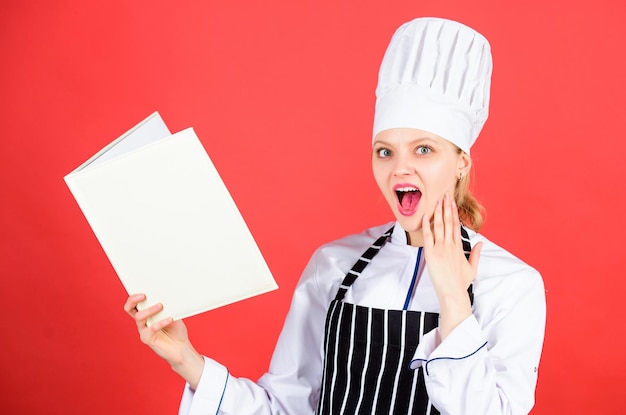 Kochen und Kulinarisches als Hobby Frau liest Kochbuch in der Küche Tipps und Ratschläge Kochen von Speisen Lecker und Gourmet Koch sucht nach Kochrezept in Kochbuch Chefautor kulinarisches Buch
