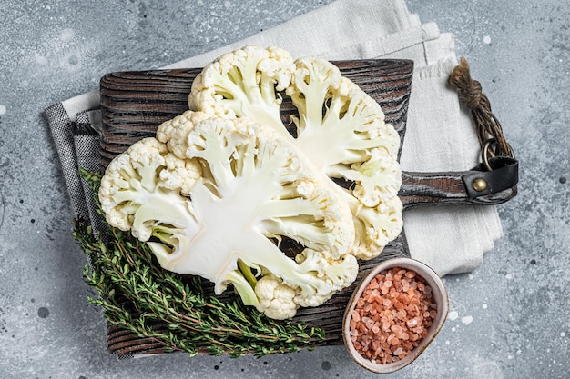 Kochen von Blumenkohlsteak Vegetarische Küche Grauer Hintergrund Ansicht von oben