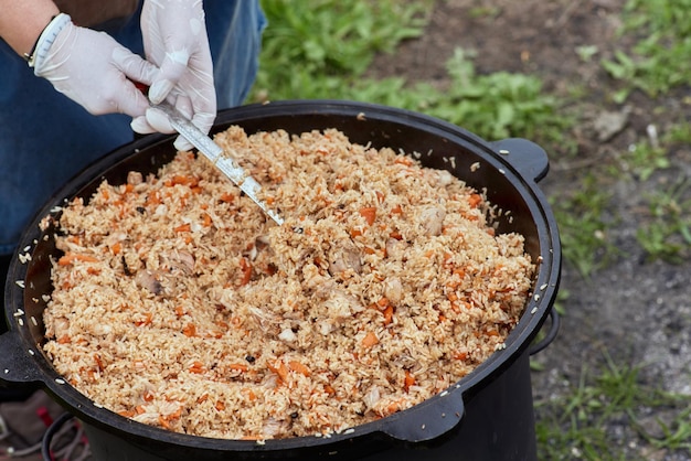 Kochen von essen oder pilaw in einem brennenden kessel kochen im kessel auf offenem feuer in der natur bowler am lagerfeuer im wald closeup feuer flamme