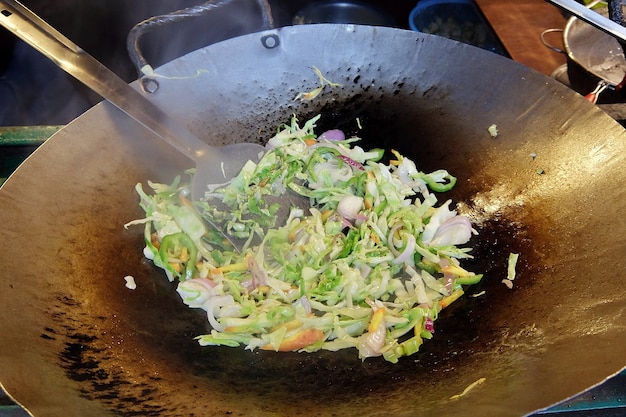 Kochen von Gemüse im Wok für gebratene Gemüsenudeln mit Gemüse-Chowmein Streetfood in Rishikesh, Indien