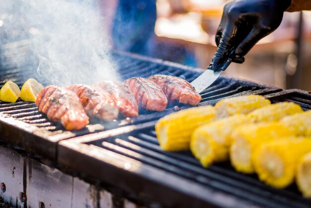 Kochen von GrillfischBehandschuhte Hände drehen Fischstücke auf dem Grill