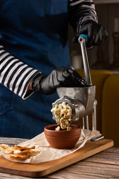 Kochen von Hackfleisch für Fischkoteletts mit Zutaten auf einem Tisch mit einem Fleischwolf.