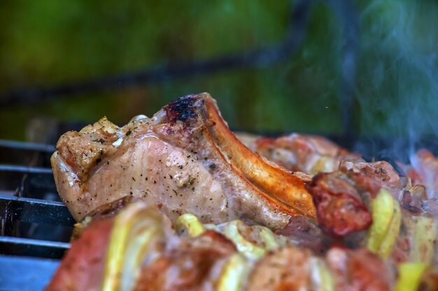 Foto kochen von kebabs auf einem grill mit rauch frisches braunes bbq-fleisch, das auf einem außengrill gekocht wird