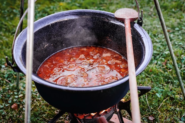 Kochen von Rindergulaschsuppe in einem Kessel Kochen in einer natürlichen Umgebung in einem Topf auf offenem Feuer