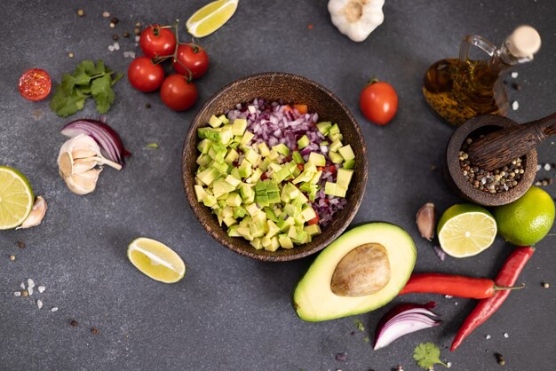 Kochen von traditioneller Salsa mit geschnittenen Zutaten in einer Holzschüssel