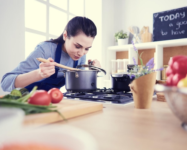 Kochende Frau in der Küche mit Holzlöffel