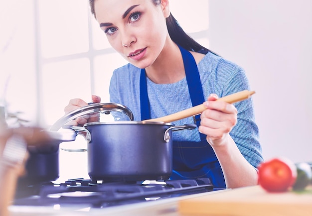 Kochende Frau in der Küche mit Holzlöffel