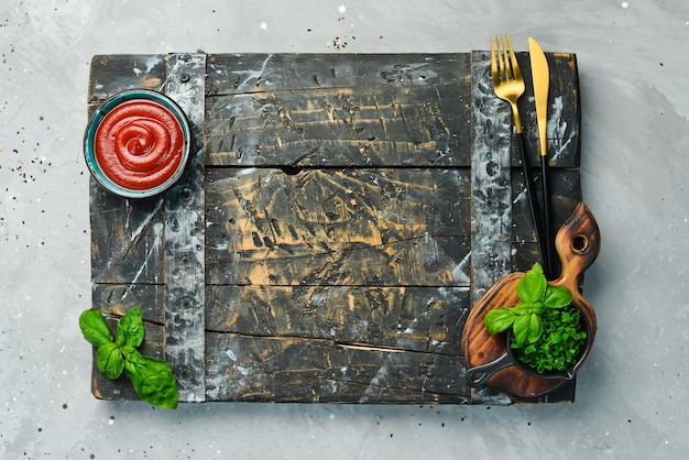 Kochhintergrund Zusammensetzung von Gemüse, Gewürzen, Öl und Küchenutensilien auf einem grauen Steintisch Draufsicht Freier Platz für Ihren Text
